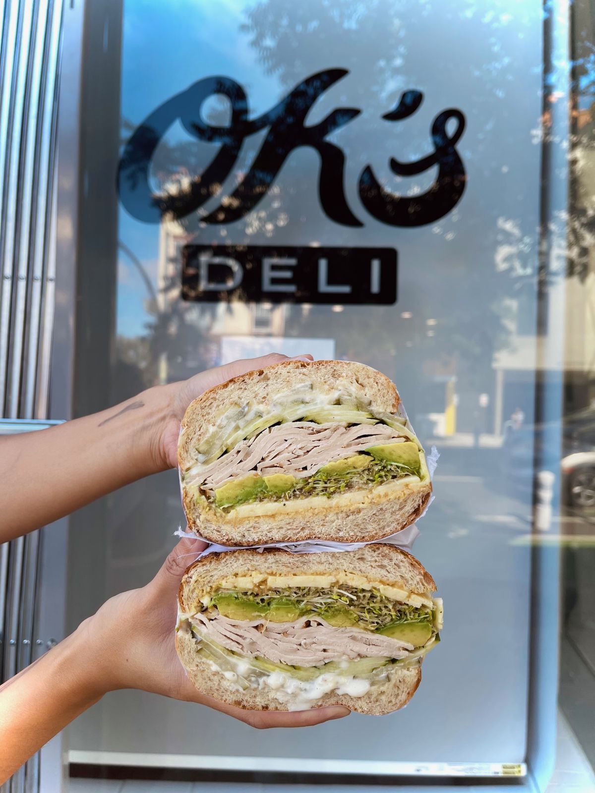 A bisected sandwich is shown in front of the entrance to Ok’s Deli in Oakland.
