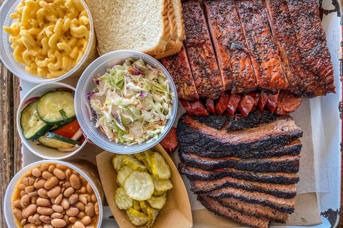 A tray of barbecue meats and sides. 