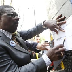 Randolph Holder Sr. traces his son's name from the New York State Police Officers' Memorial on Tuesday, May 10, 2016, in Albany, N.Y. New York City Police Department Det. Randolph Holder, who died in the line of duty, was one of 26 officers added to the memorial. 