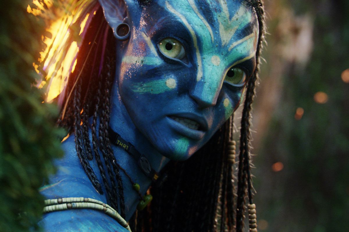 Neytiri, a blue-skinned alien with big eyes and tight braids in her hair (Zoe Saldana), in Avatar.