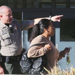 An officer directs a parent where to go to pick up a student at Mountain View High School in Orem after five students were stabbed in an apparent attack by a 16-year-old boy on Tuesday, Nov. 15, 2016.