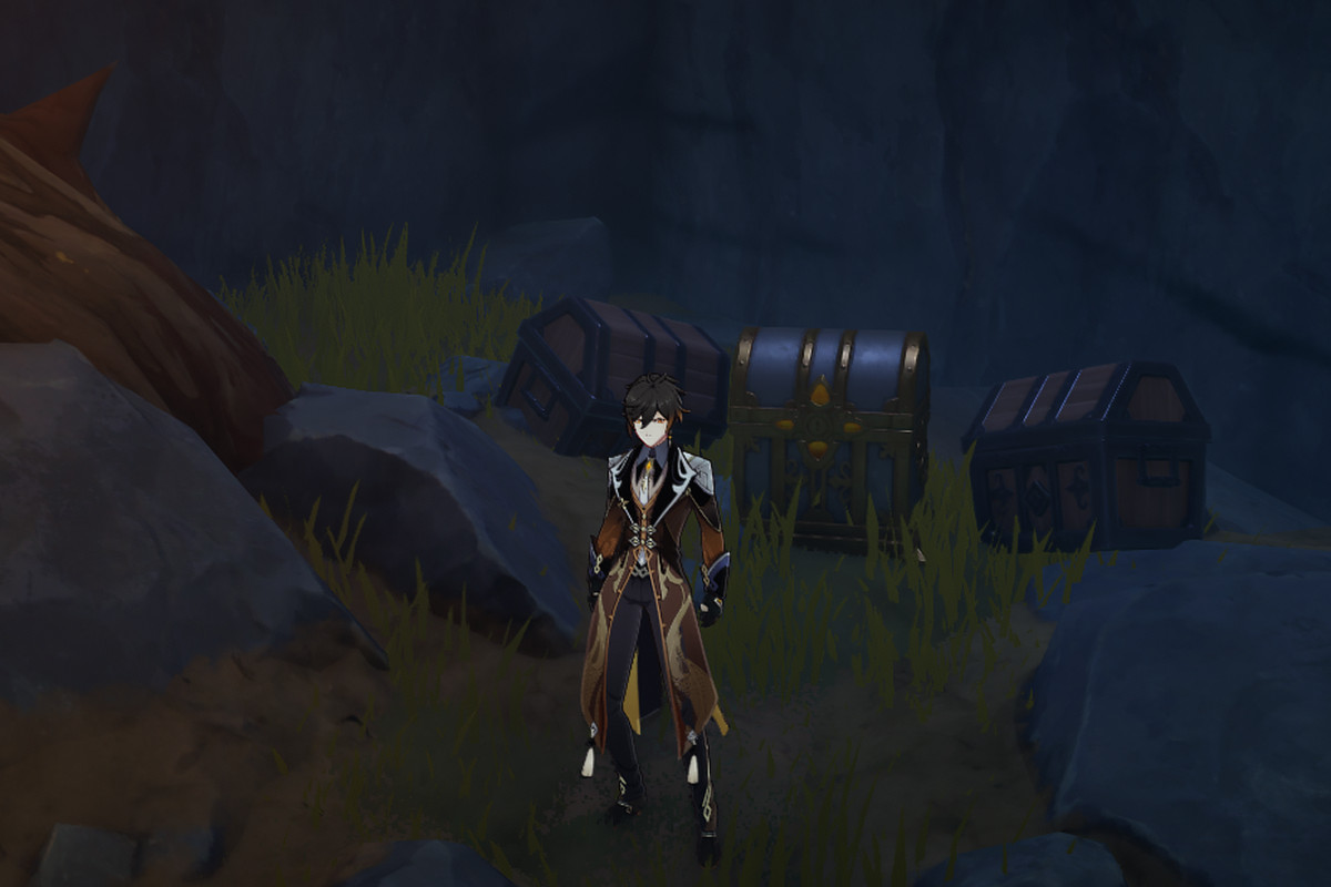 Zhongli stands in front of three chests in a dark cave