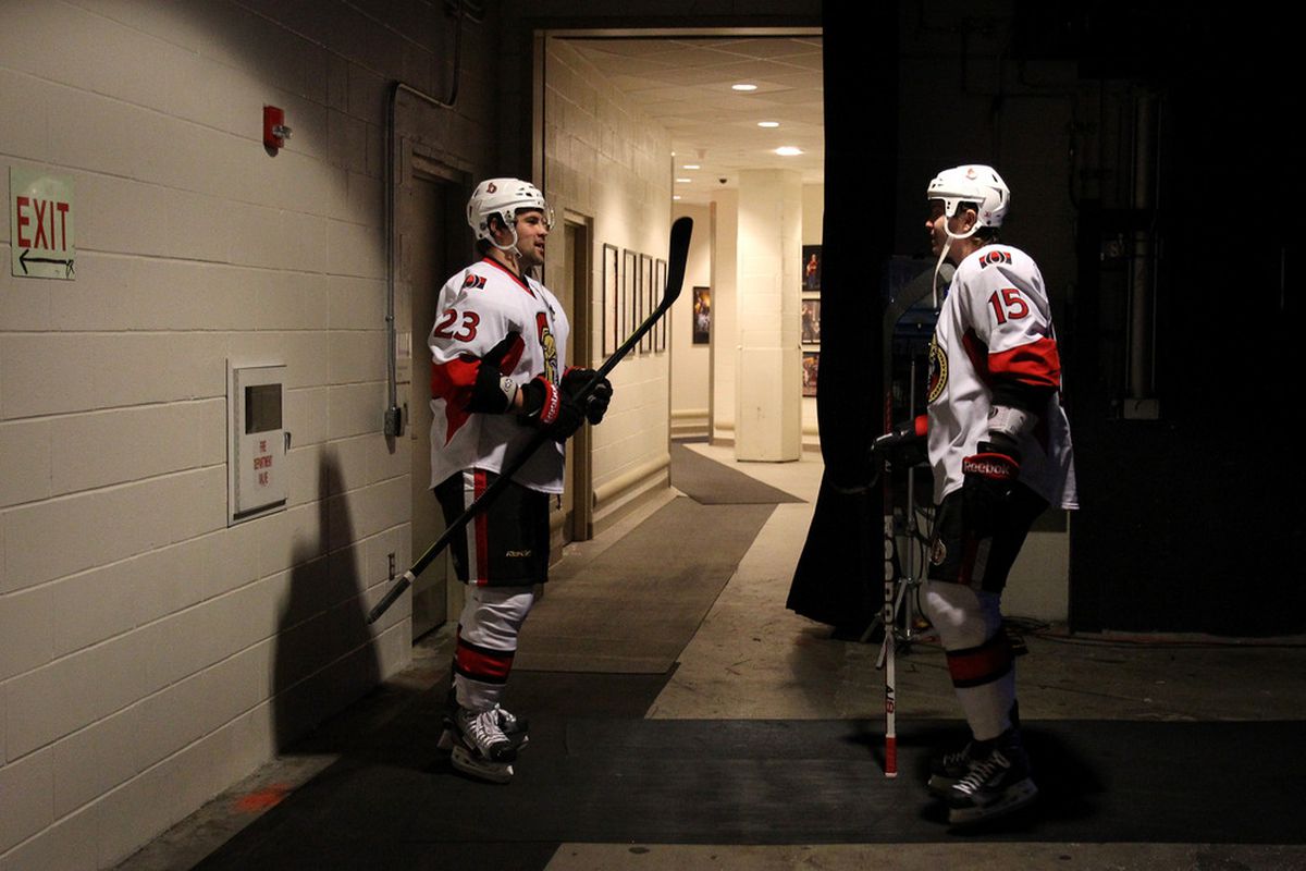 Kaspars Daugavins and Zack Smith talk in a dark room whether one of them could be traded. (Photo by Bruce Bennett/Getty Images)
