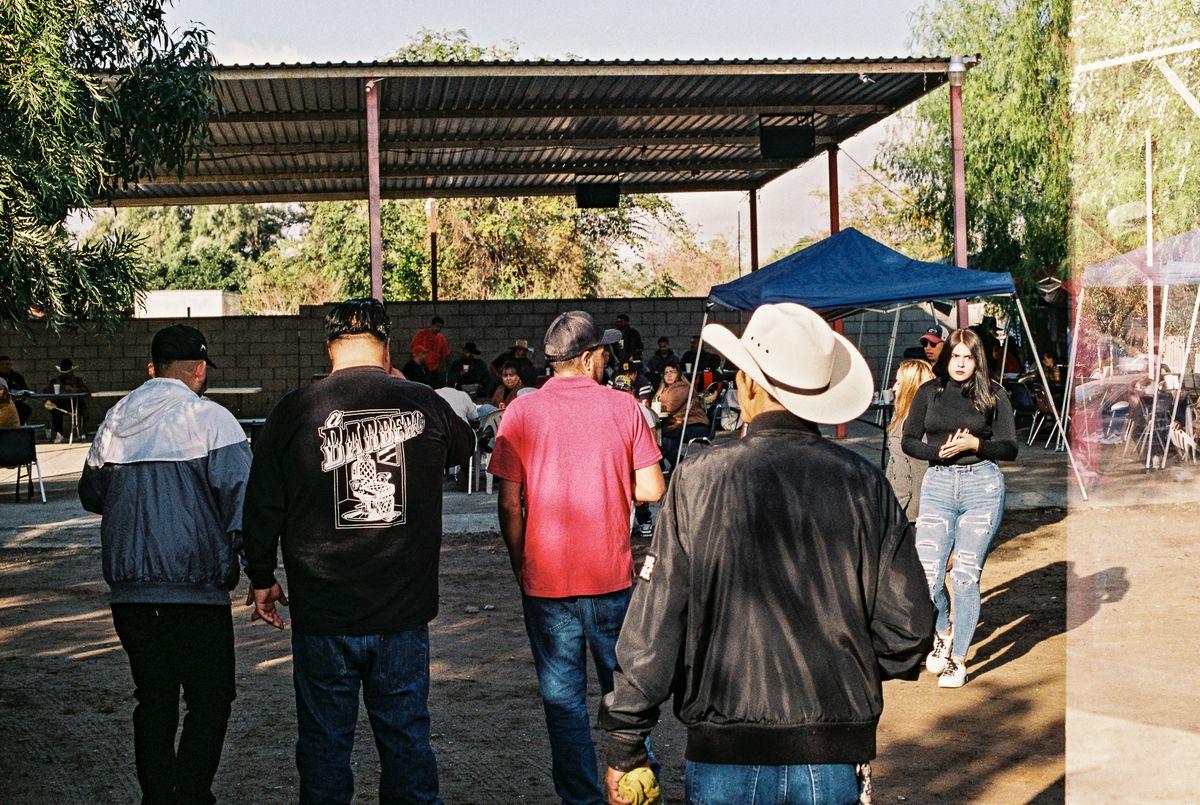 Customers stand around sipping milk cocktails at a pajaretes ranch.