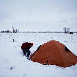 In this Wednesday, Nov. 30, 2016 photo, Roy Tom of Ontario, Canada, and a member of the Ojibwa Native American tribe clears away snow from his tent where he's lived for over two months at the Oceti Sakowin camp where people have gathered to protest the Dakota Access oil pipeline, in Cannon Ball, N.D. "You have to get used to it," Tom said of the snow and cold weather. 