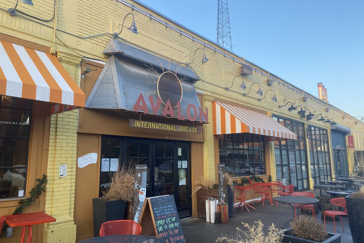 The exterior of Avalon Bakery in yellow brick with an orange sign that says Avalon International Breads above the entrance door in Midtown, Detroit, Michigan.