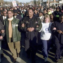 Rev. Jesse Jackson, center, and Rep. Bobby Rush, D-Ill., left, lead a chanting group of some 2,000 people through the streets of Decatur, Ill., Sunday, Nov. 14, 1999, in support of seven expelled high school students. The students, now dubbed the Decatur Seven, were conditionally expelled for two years after allegedly taking part in a brawl at a football game.