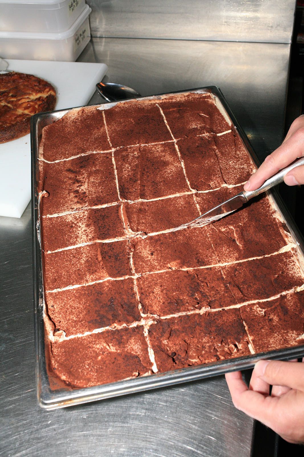 The tiramisù is marked into portions with a knife.