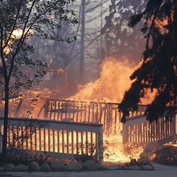 A the porch of a house burns down in Lake Arrowhead, Calif., Monday.