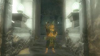 Link porte l'armure chargée tout en se tenant dans un couloir éclairé à Zelda Tears of the Kingdom