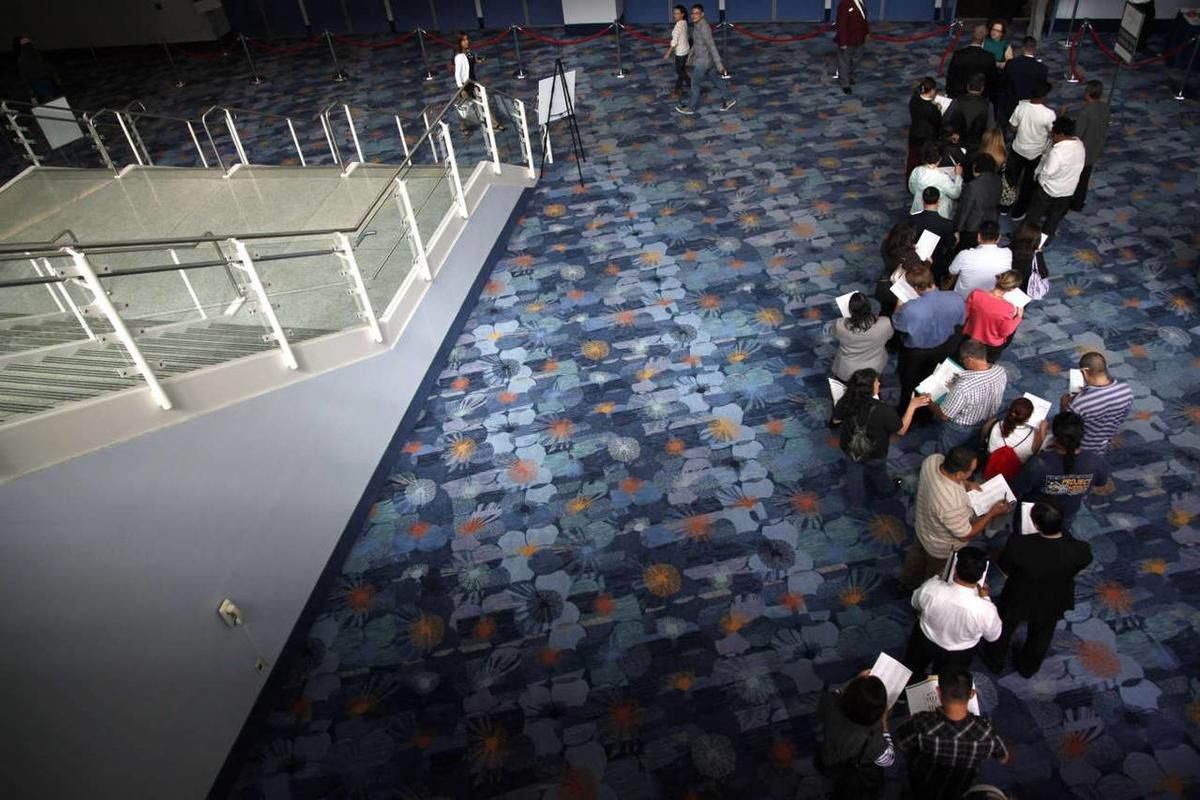 In this June 13, 2012, photo, job seekers wait in line at a job expo in Anaheim, Calif. More Americans sought unemployment benefits this week, the highest number in four months.