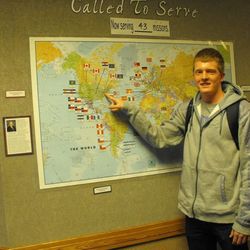 Braden Miles points to his mission destination in Washington D.C. on a world map at the Lone Peak Seminary prior to his departure.