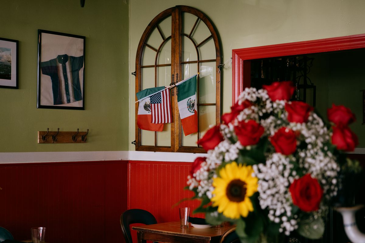 A dining room interior with hanging Mexican flags.