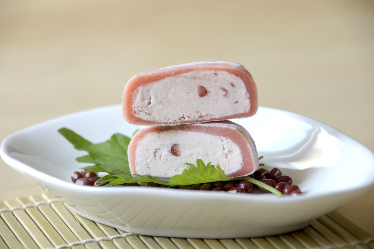 Red bean ice cream mochi cut in half on a white plate