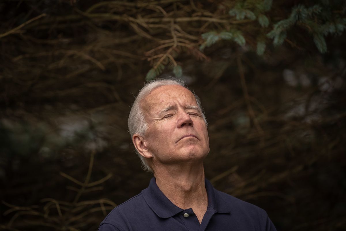 Joe Biden looks up with his eyes closed.