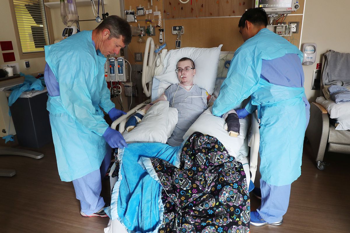 Physical therapist Walter Anyan and occupational therapist Xavier Lucio prepare burn victim Austin Weaver for physical therapy at University of Utah Health's Burn Center in Salt Lake City on Friday, July 20, 2018. Weaver's family says his life has essenti