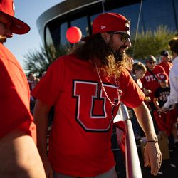 Scott Olsen, of Salt Lake City, left, and Jeff Westcoast, of Phoenix, second from left, join other Utah fans outside Allegiant Stadium in Las Vegas before the Utes face the Oregon Ducks in the Pac-12 championship game on Friday, Dec. 3, 2021.