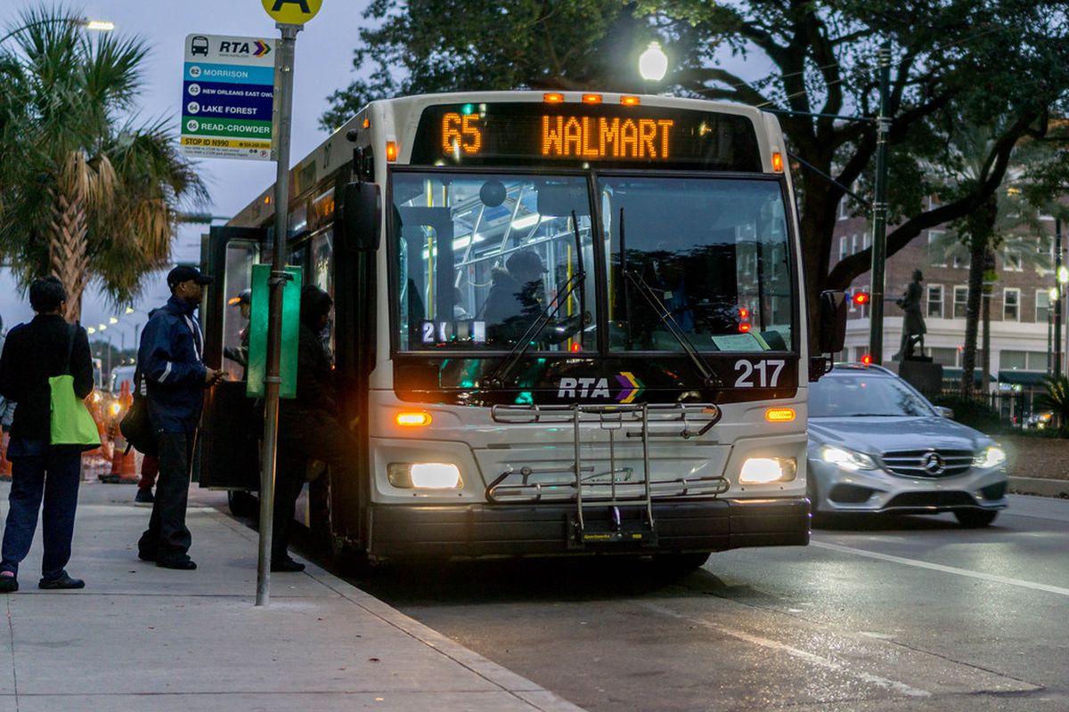 A New Orleans RTA bus picks up passengers at dusk