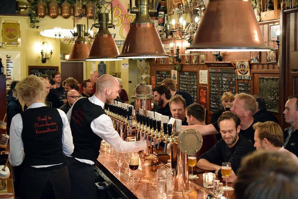 Inside a bar crowded with customers and staff in waistcoats.