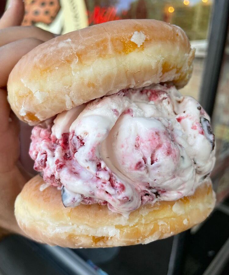 Raspberry vanilla ice cream between two glazed doughnuts. 