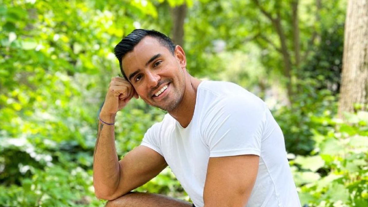 Male influencer in white t-shirt sitting in sunny backyard