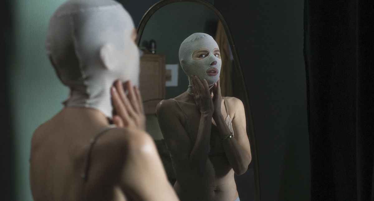 Naomi Watts wears a ski mask and looks in the mirror at Goodnight Mommy.