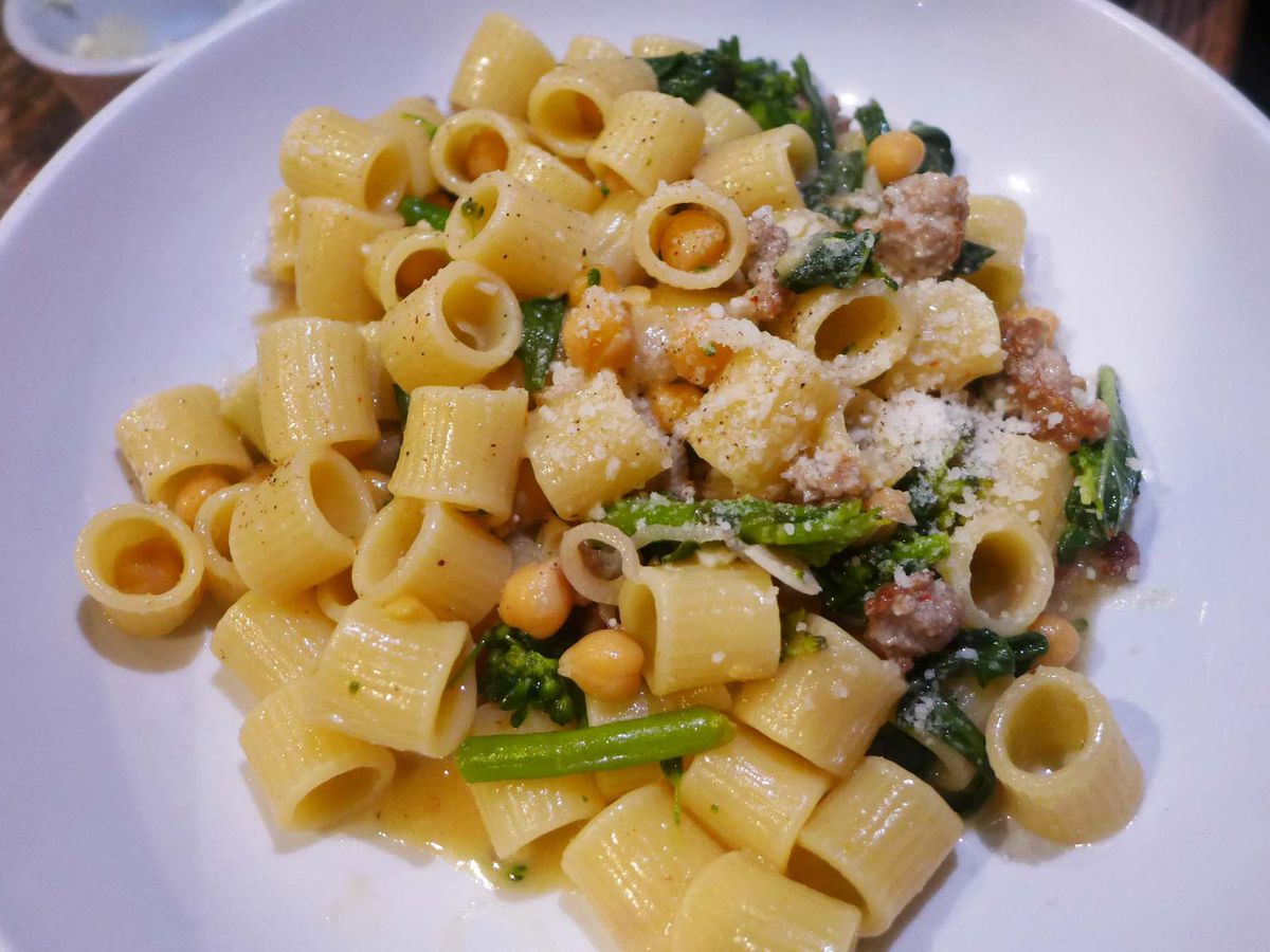 Tubes of pasta with greens and sausage.