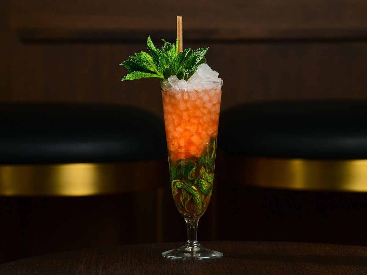 A tropical cocktail with crushed ice and mint leaves in a tall glass at Pebble Bar.