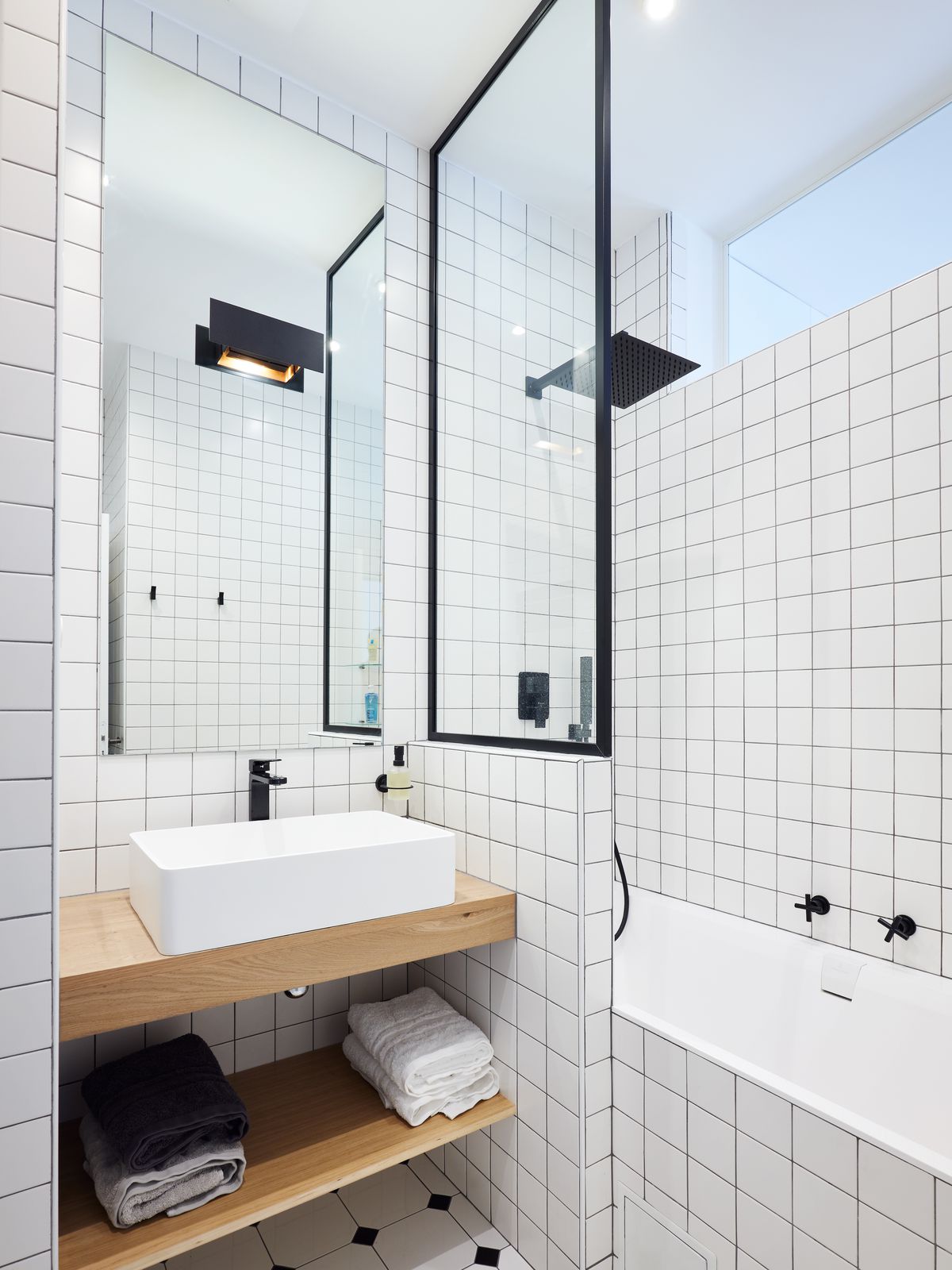 Small bathroom with subway tiled walls and a sink. 