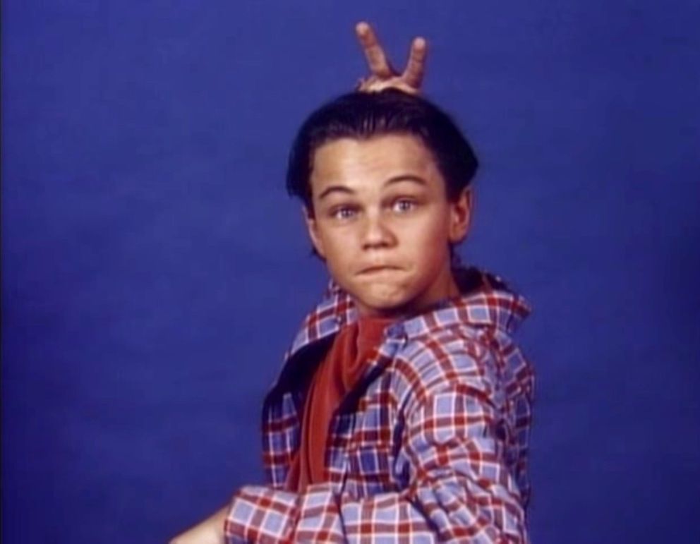 Young Leonardo Dicaprio wearing red and blue plaid giving himself bunny ears in Growing Pains