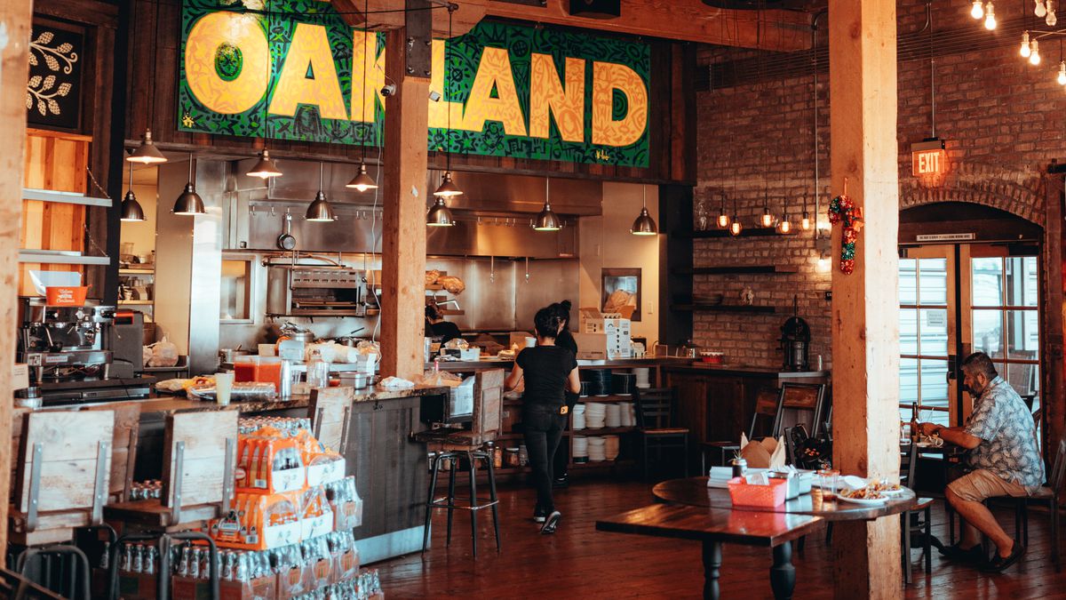 A view of the front counter of La Santa Torta’s brick-and-mortar restaurant, including a green-and-yellow sign reading “Oakland.”