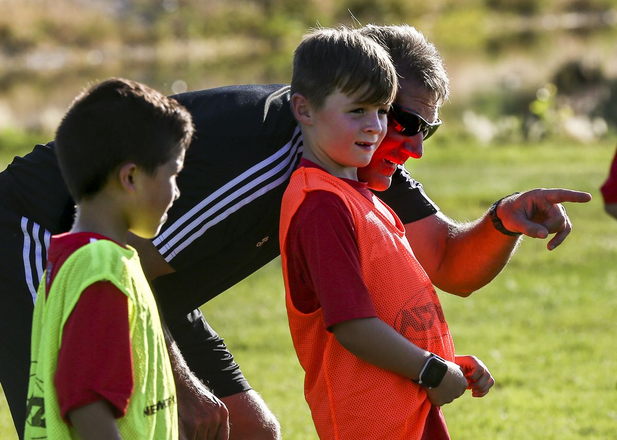 Coach Mike Raffael gives Aiden Ellis, 8, guidance between drills during a practice at North Lake Park in Lehi on Thursday, Aug. 1, 2019.