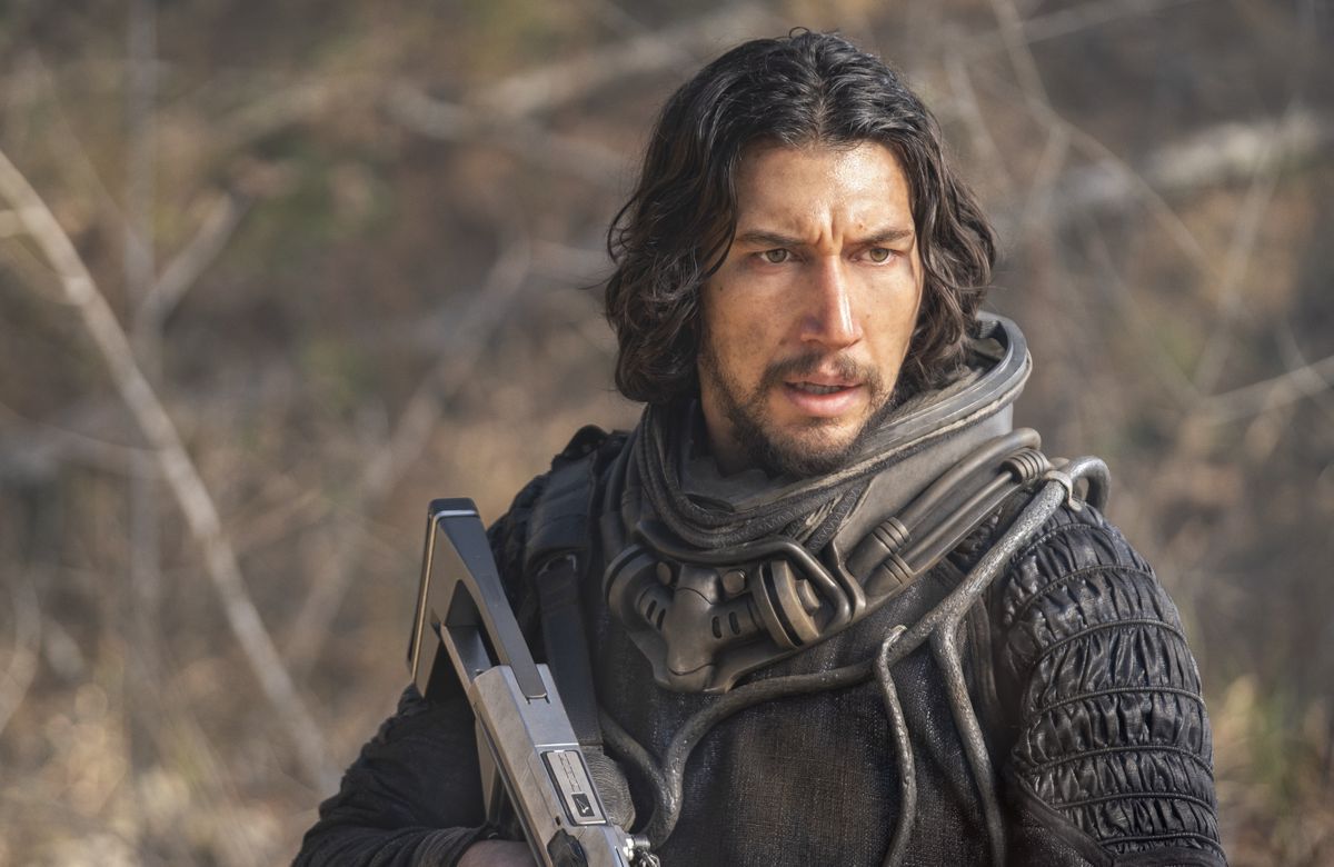 Adam Driver looks disheveled and holds a futuristic pistol in 65