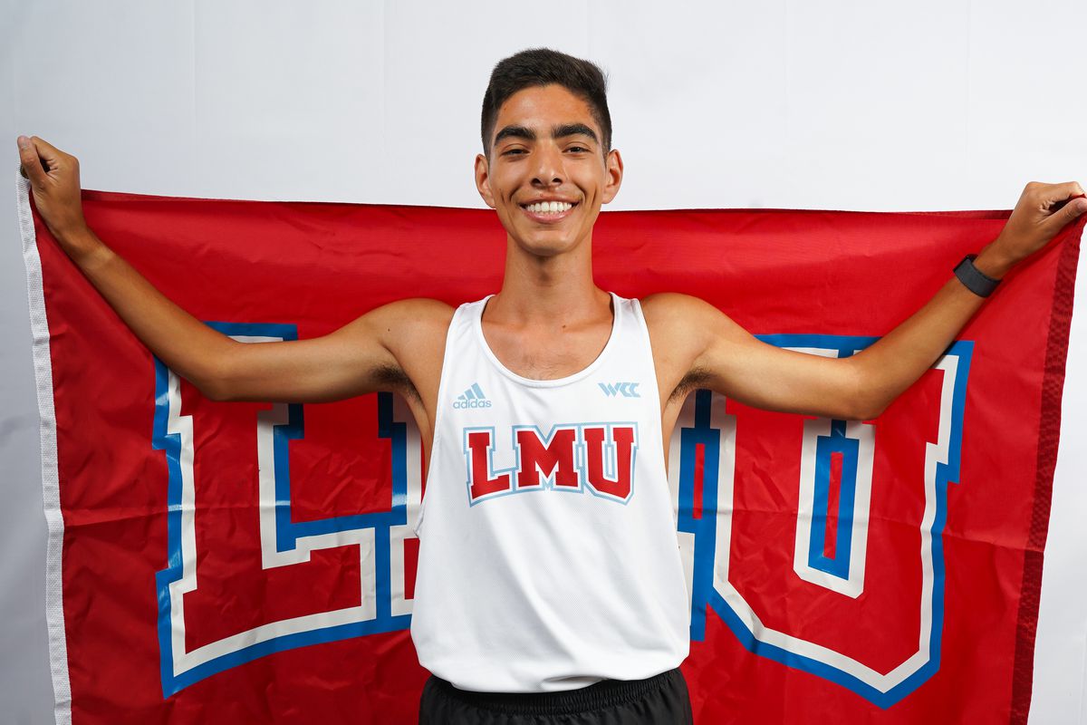 Daniel Vaca holds a banner with LMU on it.
