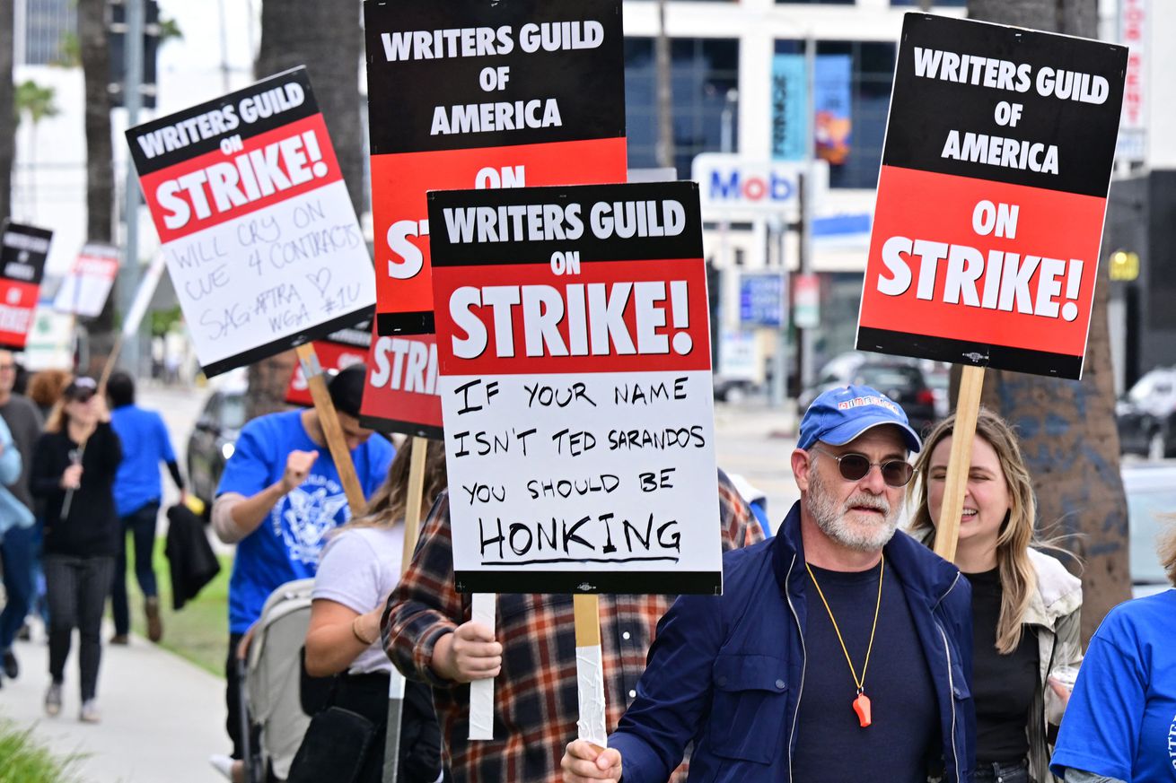 Writers hold signs on the picket line on the fourth day of the strike by the Writers Guild of America as they march past Netflix in Hollywood, California, on May 5, 2023.