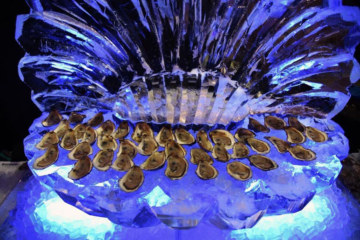 Oysters on the half shell are displayed on a giant oyster carved out of ice