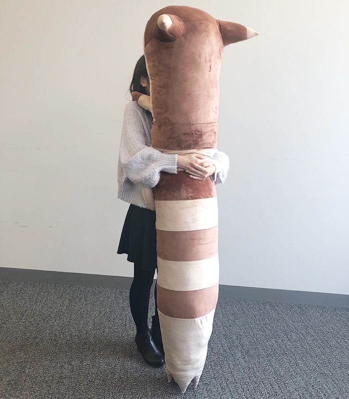 A woman hugging the life-size Furret