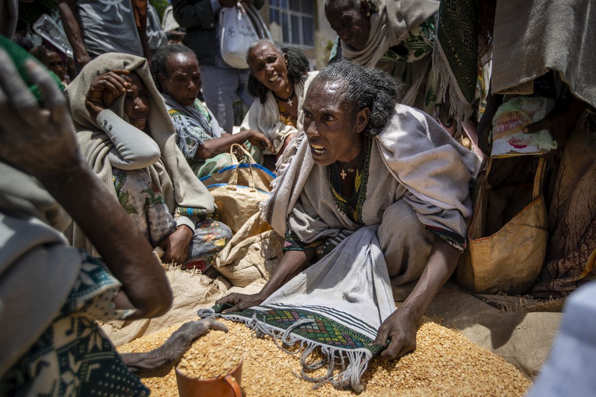 An Ethiopian woman argues with others over the allocation of yellow split peas after it was distributed by the Relief Society of Tigray in the town of Agula, in the Tigray region of northern Ethiopia, on Saturday, May 8, 2021. 