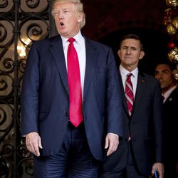 President-elect Donald Trump, left, accompanied by retired Gen. Michael Flynn, a senior adviser to President-elect Donald Trump, center, speaks to members of the media at Mar-a-Lago, in Palm Beach, Fla., Wednesday, Dec. 21, 2016. 