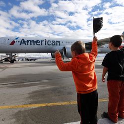 Mikhail and Keagen Rawlings wave at their sisters, Moira and Kelsie LeGrand, who are on the plane, as American Airline's 11th annual Snowball Express prepares to depart the Salt Lake International Airport on Sunday, Dec. 11, 2016, an event for children of fallen military heroes. Ten chartered American aircraft departed numerous cities — including Salt Lake City — to pick up nearly 1,800 children and spouses for an all-expense-paid journey to Dallas-Fort Worth area. While there, the families will participate in a series of activities starting with a Texas-sized welcome, a tour of the Fort Worth Museum of Science and History, a night of jousting fun at Medieval Times and a private concert by Academy Award-nominated actor Gary Sinise and the Lt. Dan Band.