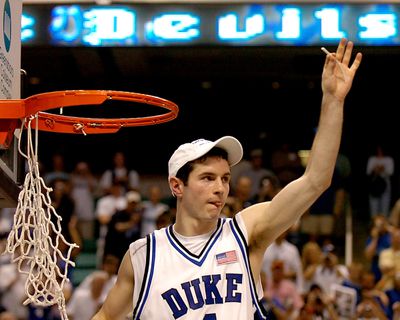 Duke’s J.J. Redick shows of a section of the cut net as his