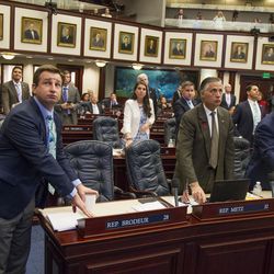 Florida Rep. Jason Brodeur, left, (R- Sanford), watches the vote board as he votes on the school safety bill which passed the House 67-50 at the Florida Capital in Tallahassee, Fla., Wednesday, March 7, 2018. (AP Photo/Mark Wallheiser)