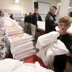 Chase Hansen, 9-year-old CEO of Kid Labs and a Leesa “social changemaker,” helps unwrap mattress covers at the Rescue Mission of Salt Lake on World Homeless Day in Salt Lake City on Wednesday, Oct. 10, 2018. Leesa Sleeps donated 150 mattresses to the mission.
