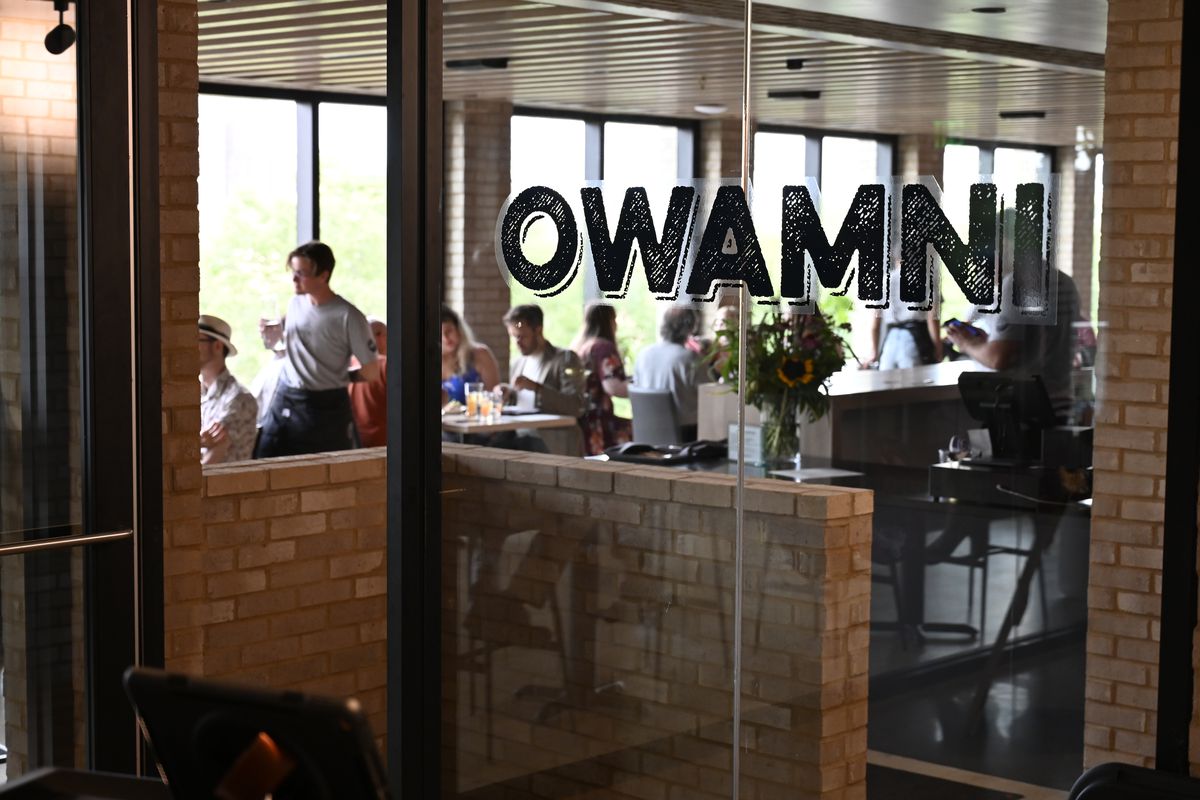 A glass door into a restaurant with a decal that says “Owamni.”