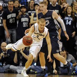 Brigham Young Cougars guard Tyler Haws (3) drives around Utah State Aggies forward Kyle Davis (23) after snagging a rebound during a game at EnergySolutions Arena on Saturday, November 30, 2013.