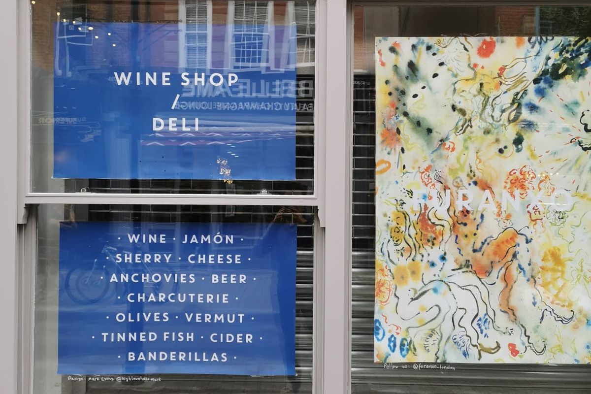 A grey window frame with decals advertising Furanxo, a wine shop and deli