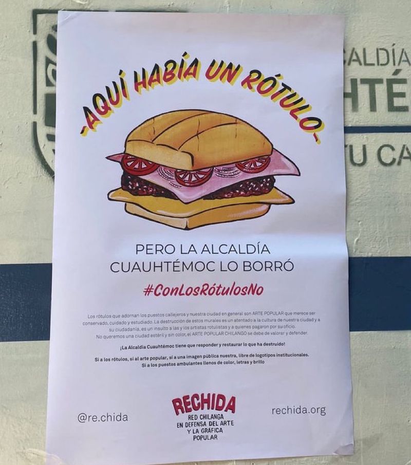 A flyer, pasted to a wall on top of city government signage, that reads Aquí había un rótulo, pero la alcadía Cuahtémoc lo borró #conlosrótulosno