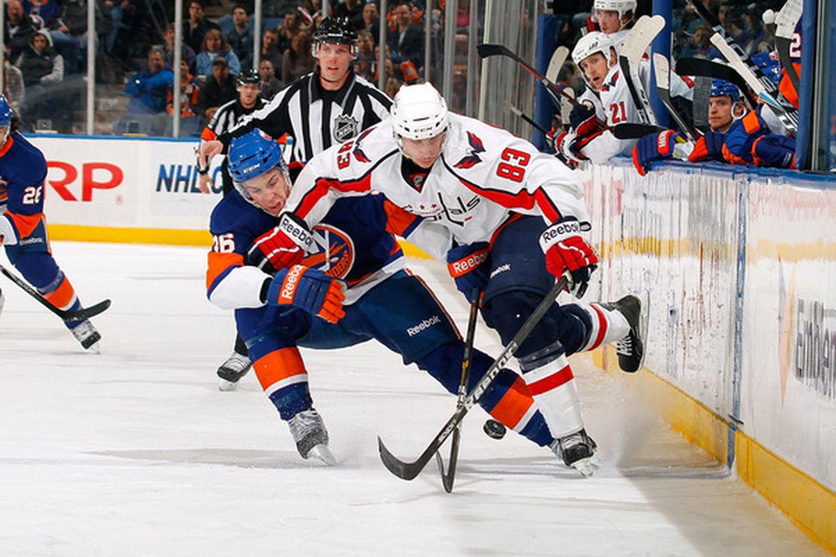 UNIONDALE NY - JANUARY 20:  Jay Beagle #83 of the Washington Capitals skates for the puck against Travis Hamonic #36 of the New York Islanders on January 20 2011 at Nassau Coliseum in Uniondale New York.  (Photo by Lou Capozzola/Getty Images)