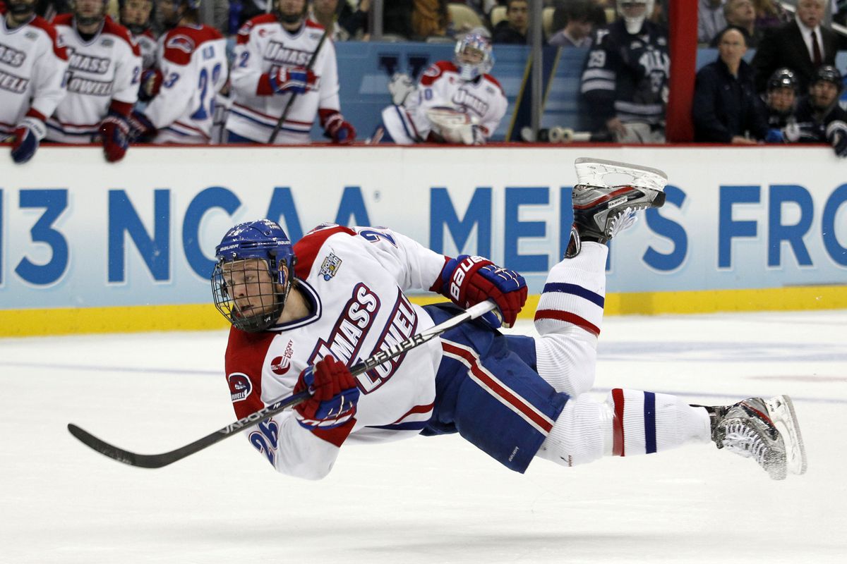 UMass Lowell defenseman Christian Folin of Sweden takes a shot while falling down.