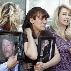 Jessica Batchelor, center, wife of Michael Batchelor, and Dena Ekins, left, and Shannon Barrowman, his sisters, talk to media while holding photos of Batchelor.